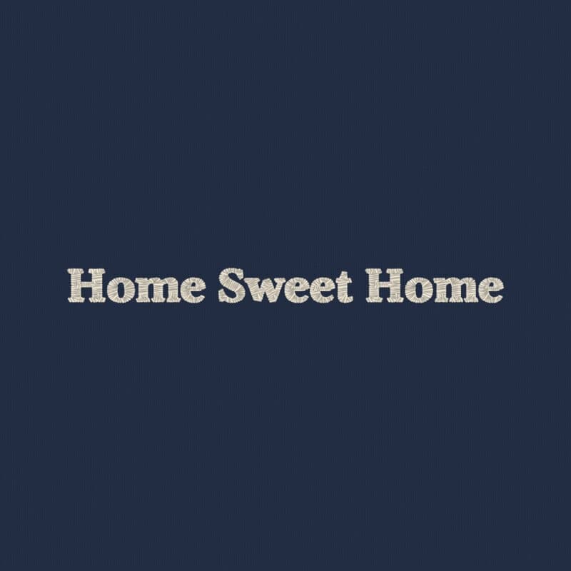 Las palabras Home Sweet Home bordadas con hilo marfil sobre tela azul marino